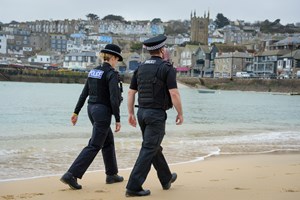 Police officers walking on beach