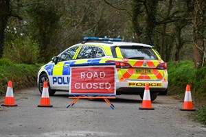 Police car, traffic cones and a 'road closed' sign