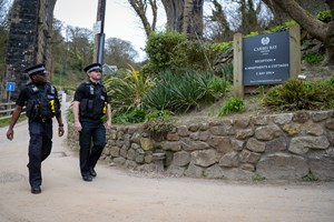 Two uniformed police officers walking outside Carbis Bay Hotel